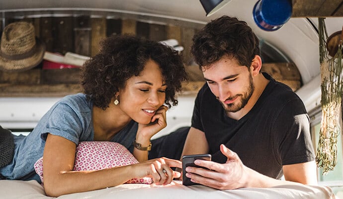 Man en vrouw die op een mobiele telefoon kijken