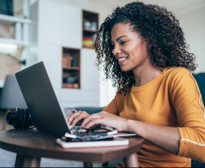 Vrouw in thuiskantoor met laptop.