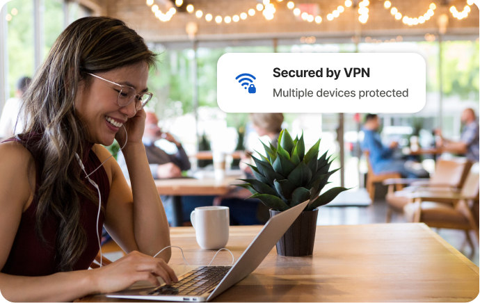 Vrouw in een café lacht naar een laptopscherm